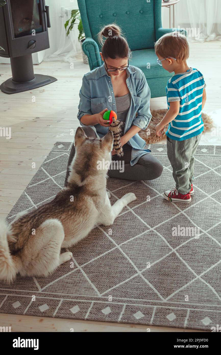Mamá y niño se divierten y juegan con el perro en casa Fotografía de stock  - Alamy