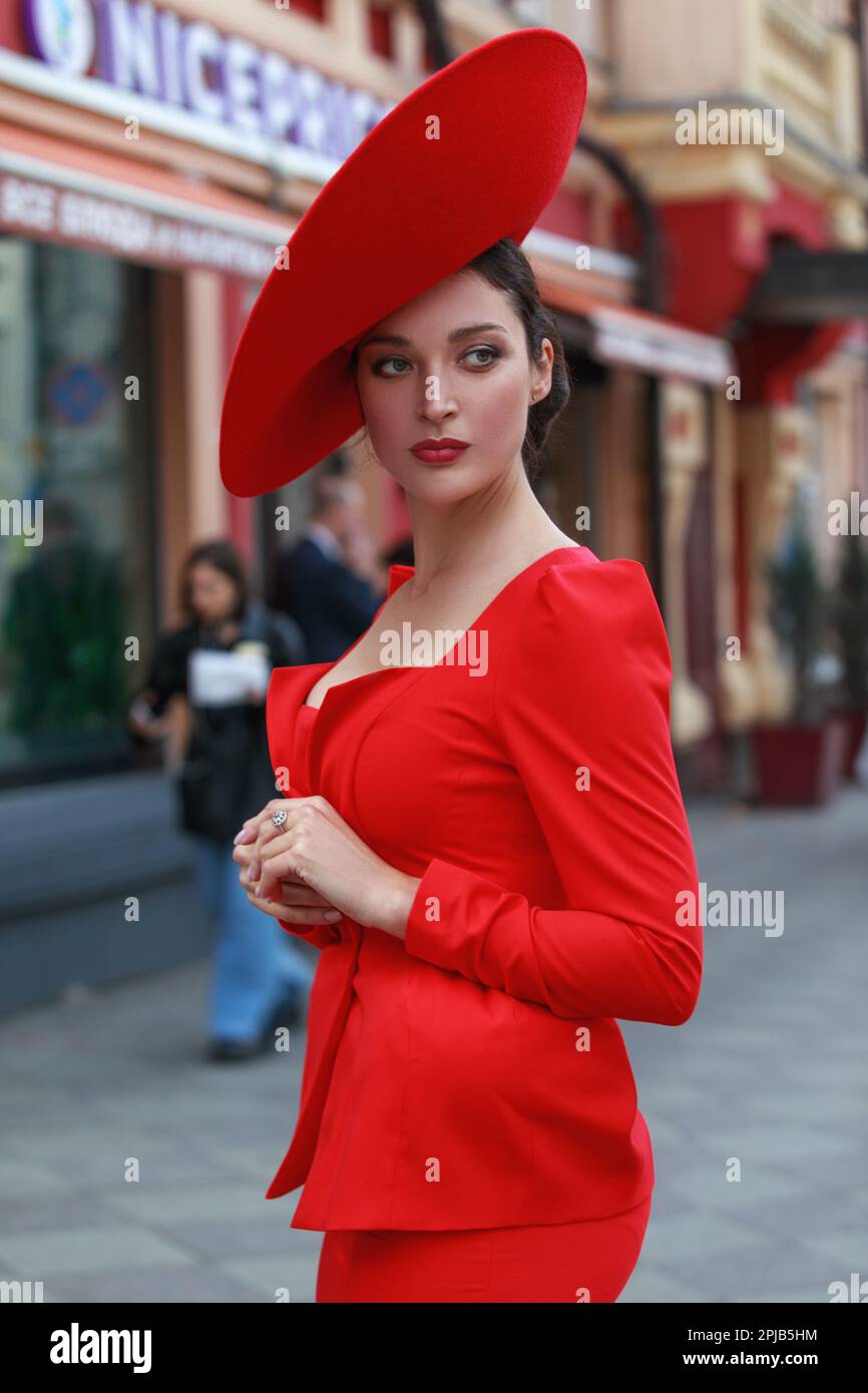 Mujer joven en sombreros elegantes posando Fotografía stock - Alamy