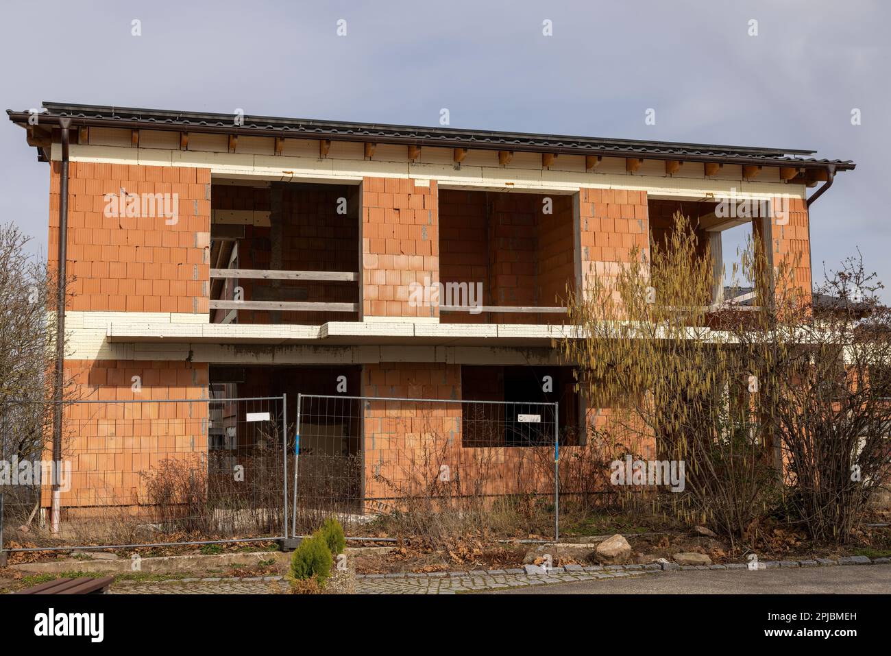 Vista de la cáscara de ladrillo rojo de dos pisos de una casa residencial en  un día nublado de invierno Fotografía de stock - Alamy