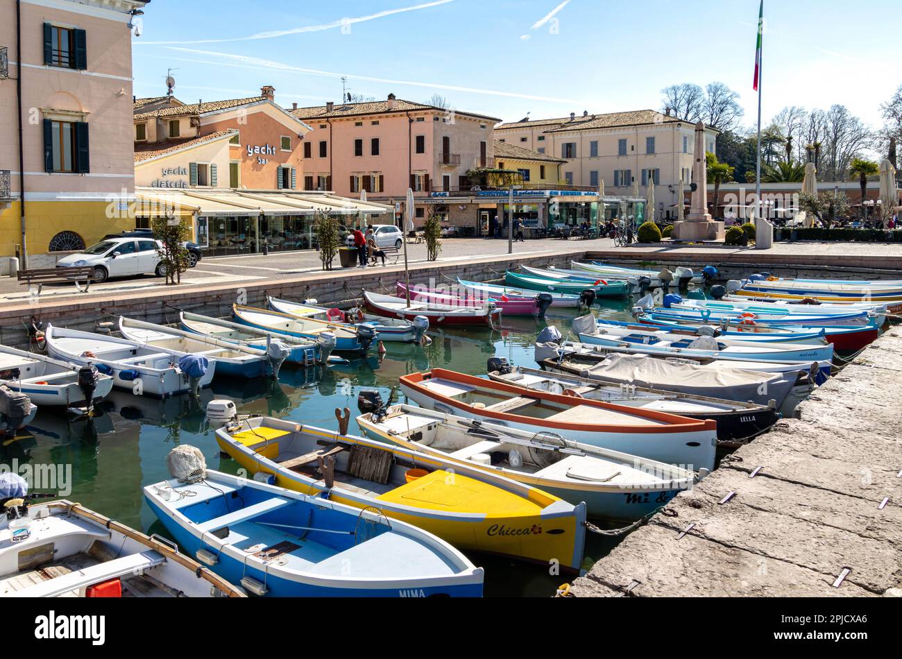 Bardolino, Lago de Garda, Italia - 29 de marzo de 2023 Coloridos barcos de pesca en el puerto de Bardolino Foto de stock