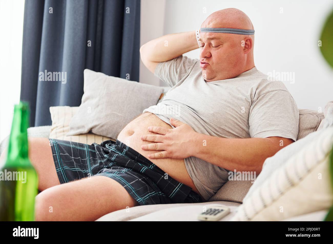 Hombre gordo divertido en ropa casual est en el interior en casa