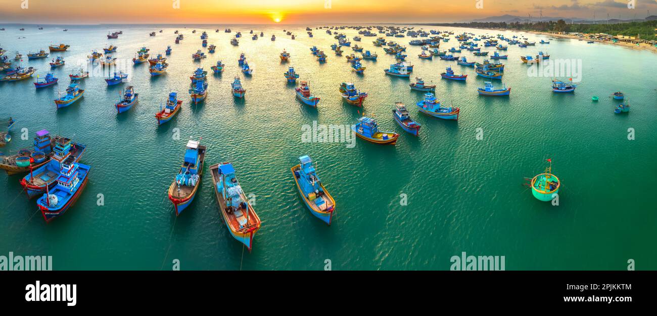 Vista aérea del pueblo pesquero de Mui Ne en el cielo del atardecer con cientos de barcos anclados para evitar tormentas, esta es una hermosa bahía en el centro de Vietnam Foto de stock