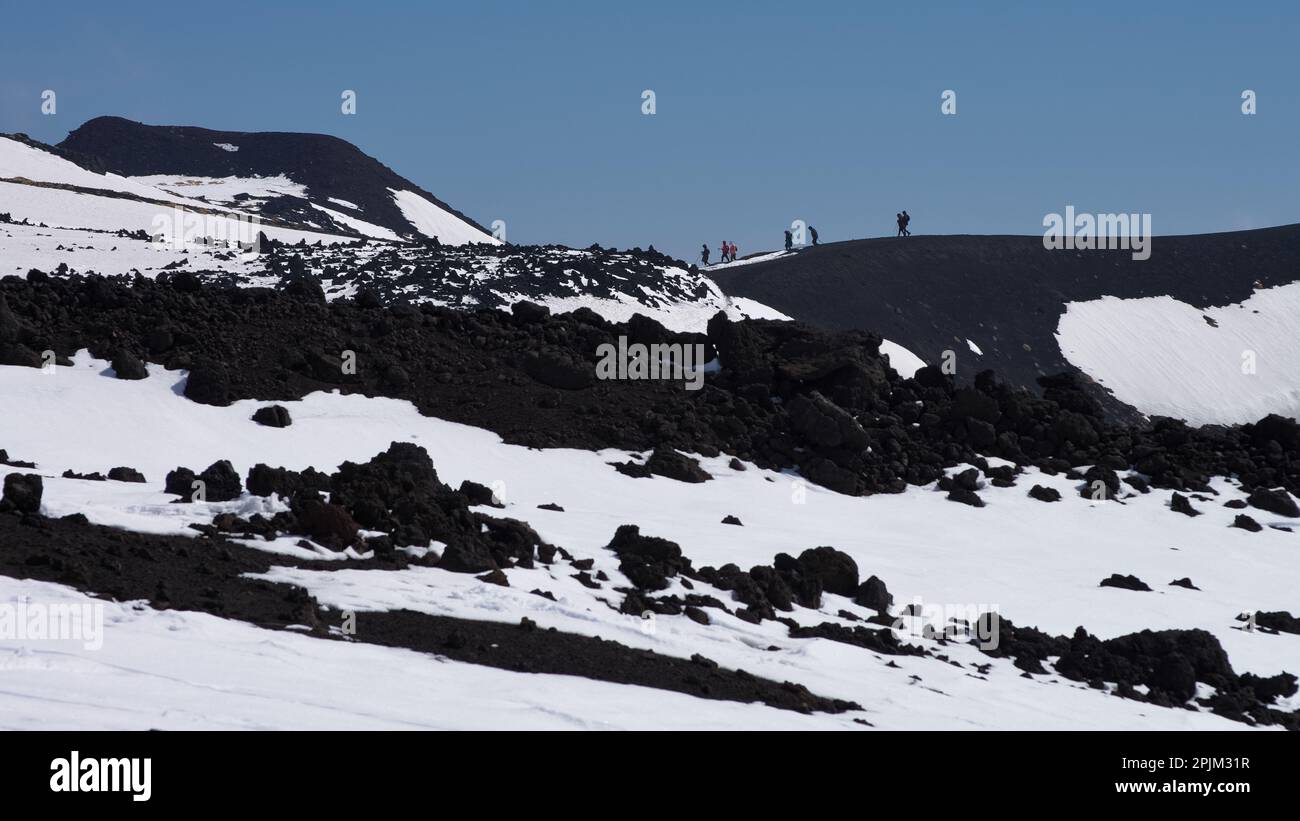Paisaje minimalista con silueta de personas distantes caminando en invierno Parque Nacional Etna, Sicilia, Italia Foto de stock