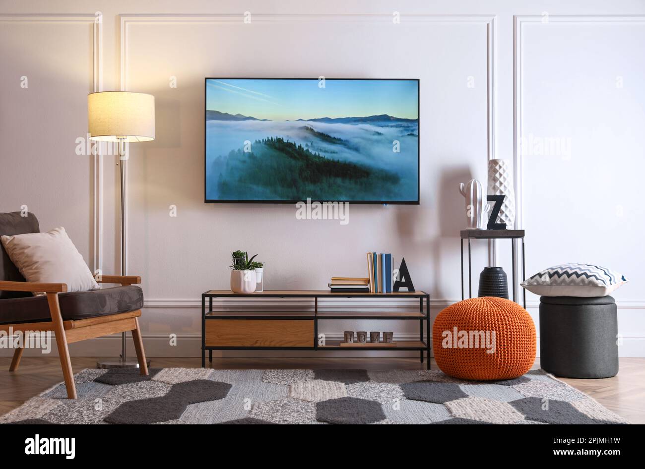 Elegante interior de la habitación con TV moderna, sillón y decoración  Fotografía de stock - Alamy
