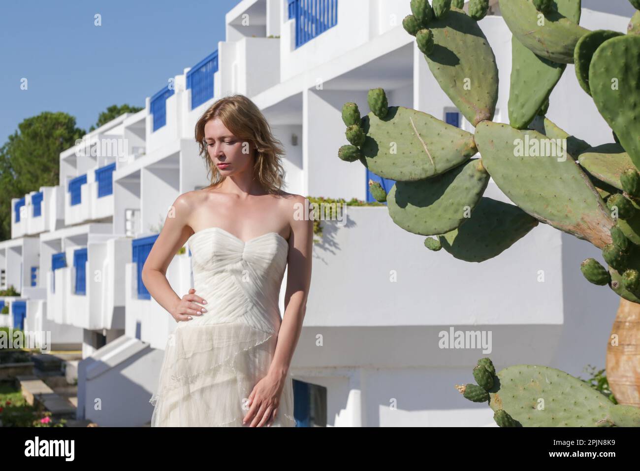 Retrato de la novia en vestido de novia blanco largo en el centro turístico, concepto de boda de destino. Isla relajado estilo boho moda nupcial. Foto de stock