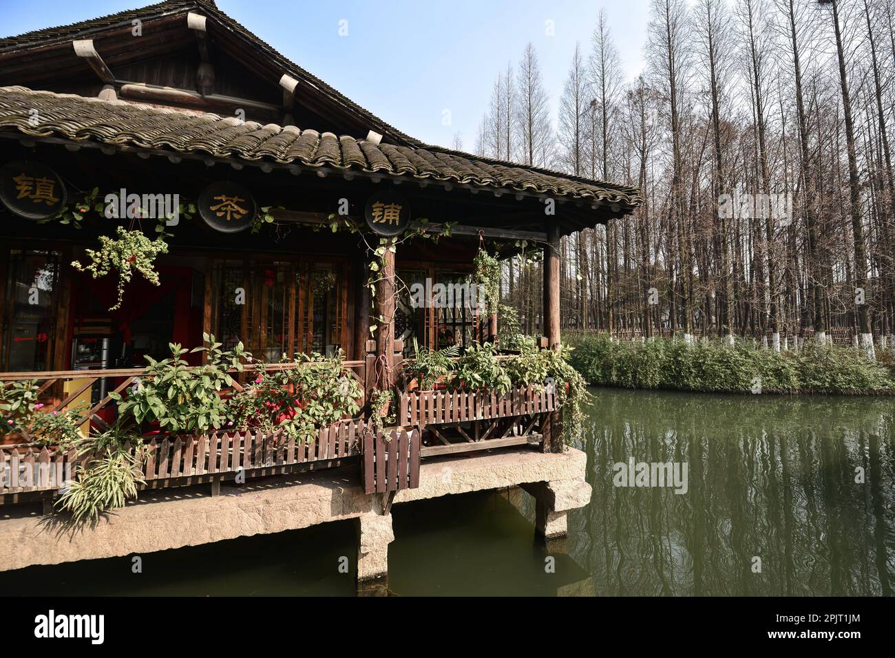 Pequeño río, barcos de madera, puentes de piedra y antiguas tiendas de madera pavimentadas con ladrillos de piedra en una pequeña ciudad de agua en el sur de China Foto de stock