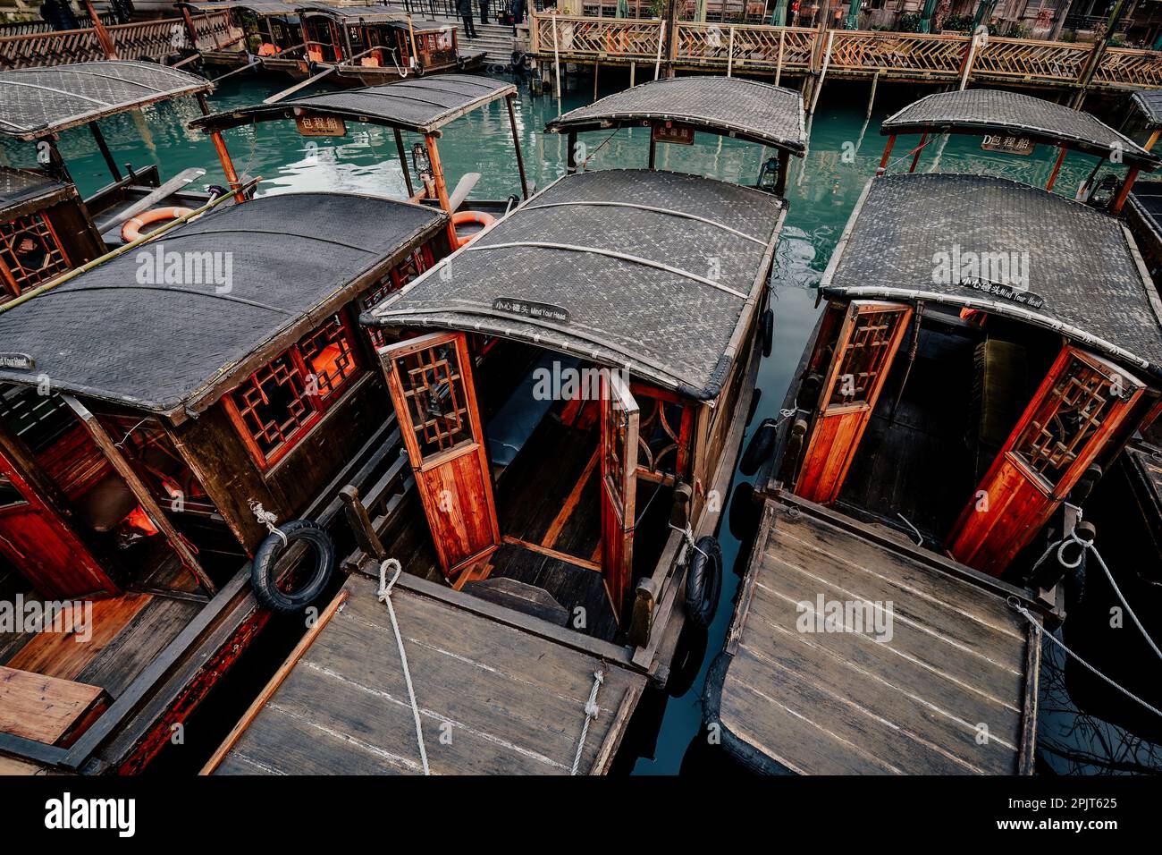 Pequeño río, barcos de madera, puentes de piedra y antiguas tiendas de madera pavimentadas con ladrillos de piedra en una pequeña ciudad de agua en el sur de China Foto de stock