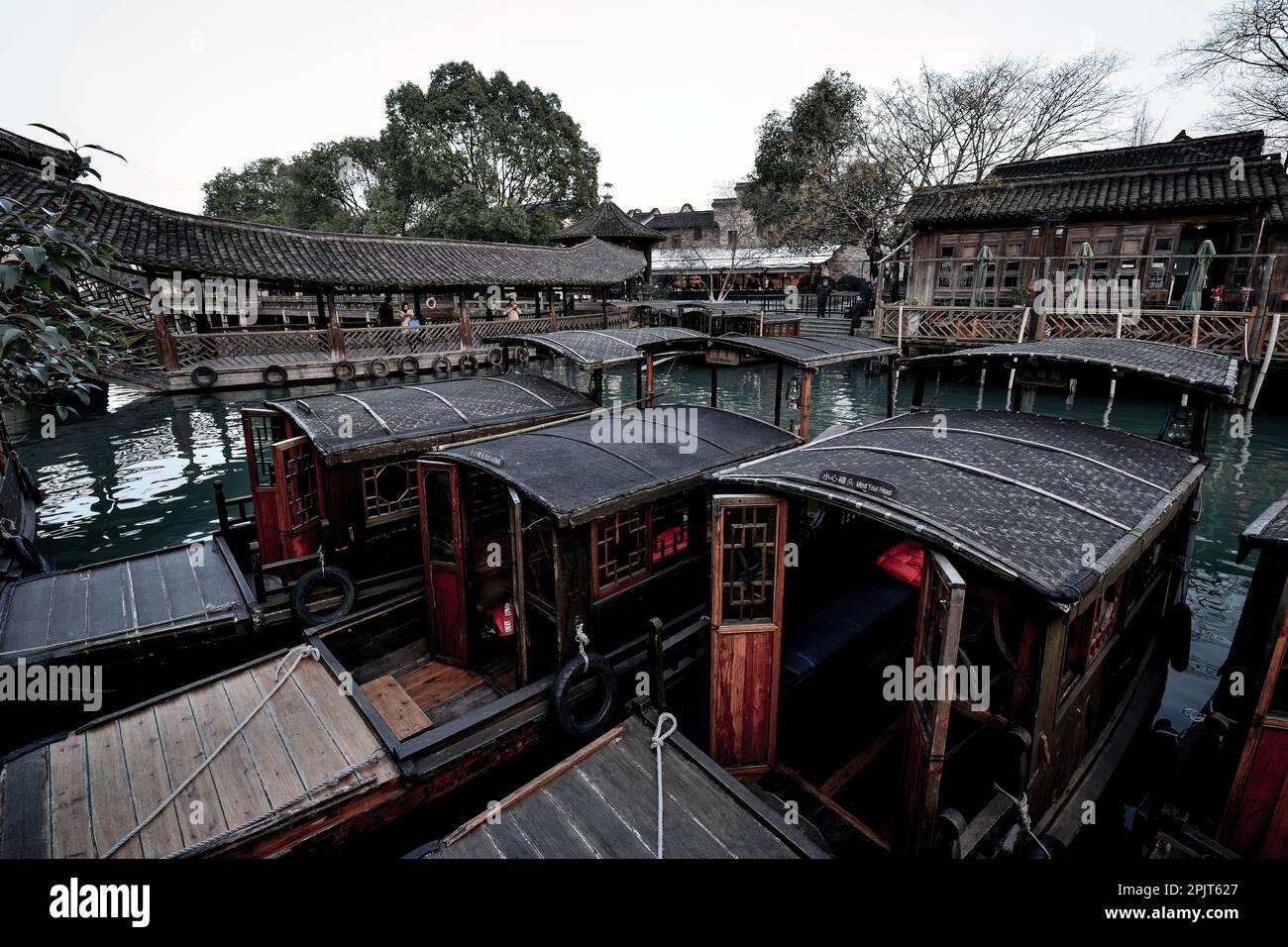 Pequeño río, barcos de madera, puentes de piedra y antiguas tiendas de madera pavimentadas con ladrillos de piedra en una pequeña ciudad de agua en el sur de China Foto de stock