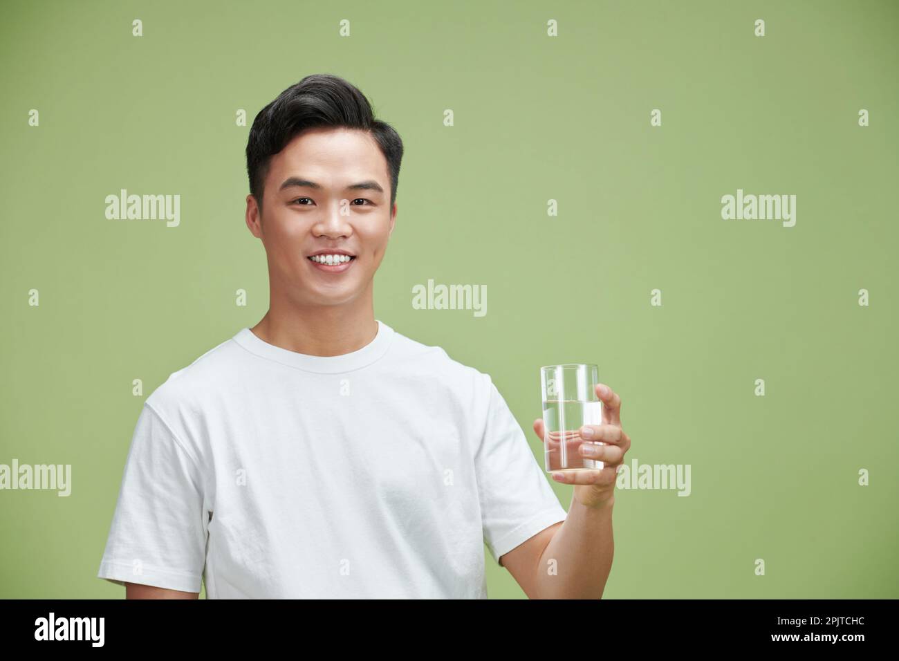 joven sostiene un vaso de agua pura Foto de stock