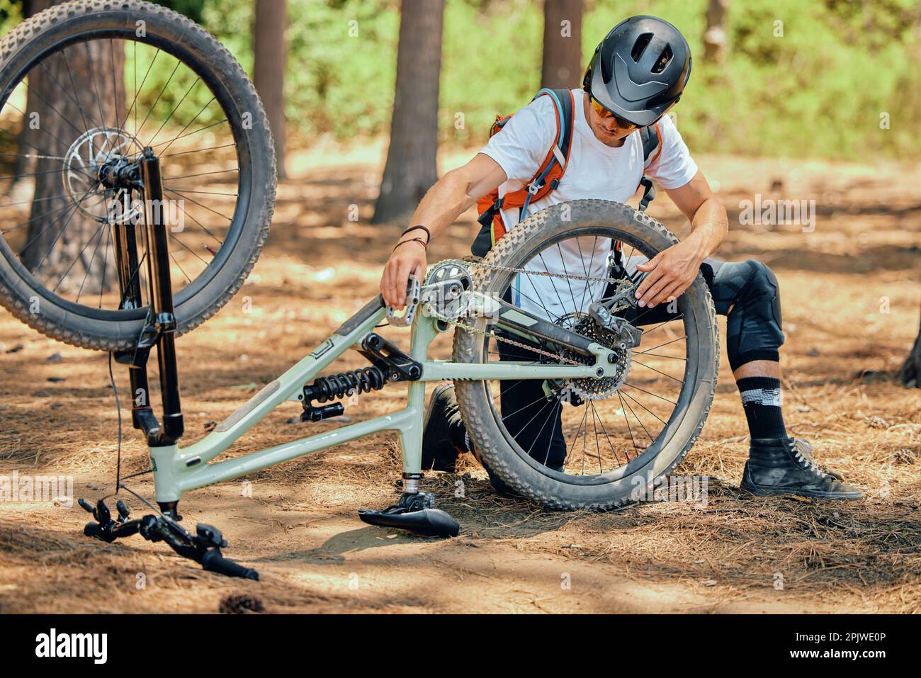 Mantenimiento, fitness y un hombre con una bicicleta para el ciclismo, la  fijación de una rueda o neumático en la naturaleza. Entrenamiento, cardio y  un ciclista reparando una bicicleta, haciendo Fotografía de