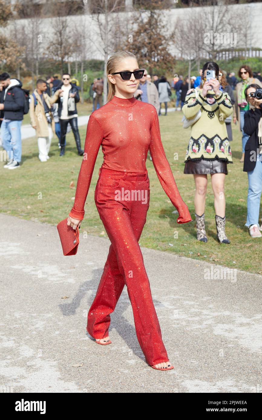 MILÁN, ITALIA - 25 DE FEBRERO de 2023: Caro Daur con cuello alto rojo y pantalones antes del desfile de Ferragamo, estilo callejero de la Semana de la Moda de Milán Foto de stock