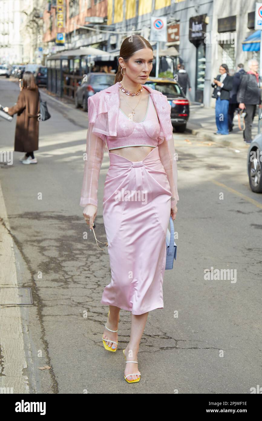 MILÁN, ITALIA - 25 DE FEBRERO de 2023: Mujer con chaqueta y falda rosa antes del desfile de Dolce y Gabbana, estilo callejero de la Semana de la Moda de Milán Foto de stock