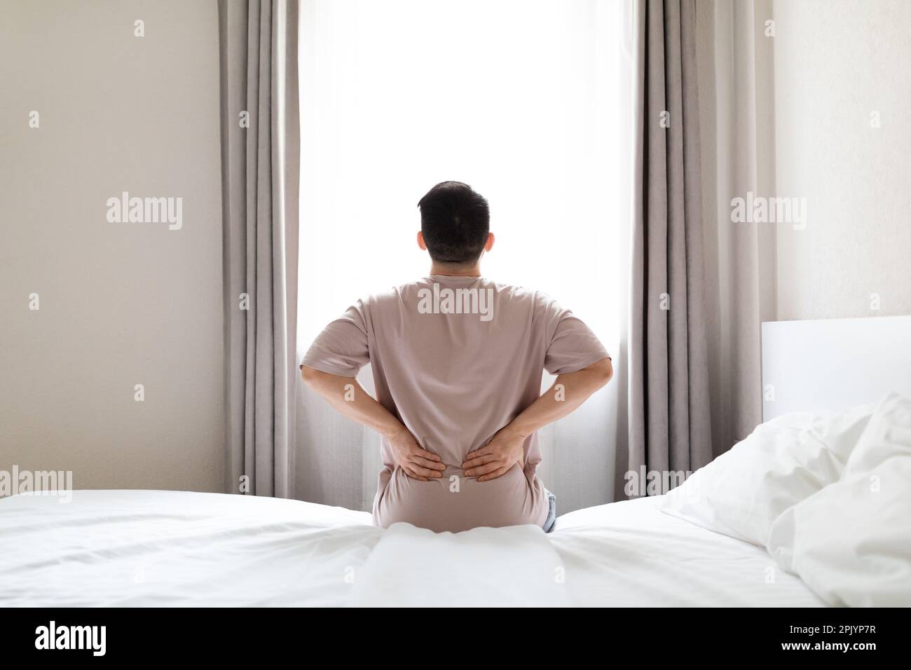 Hombre cansado que sufre de dolor de espalda después de despertar  Fotografía de stock - Alamy