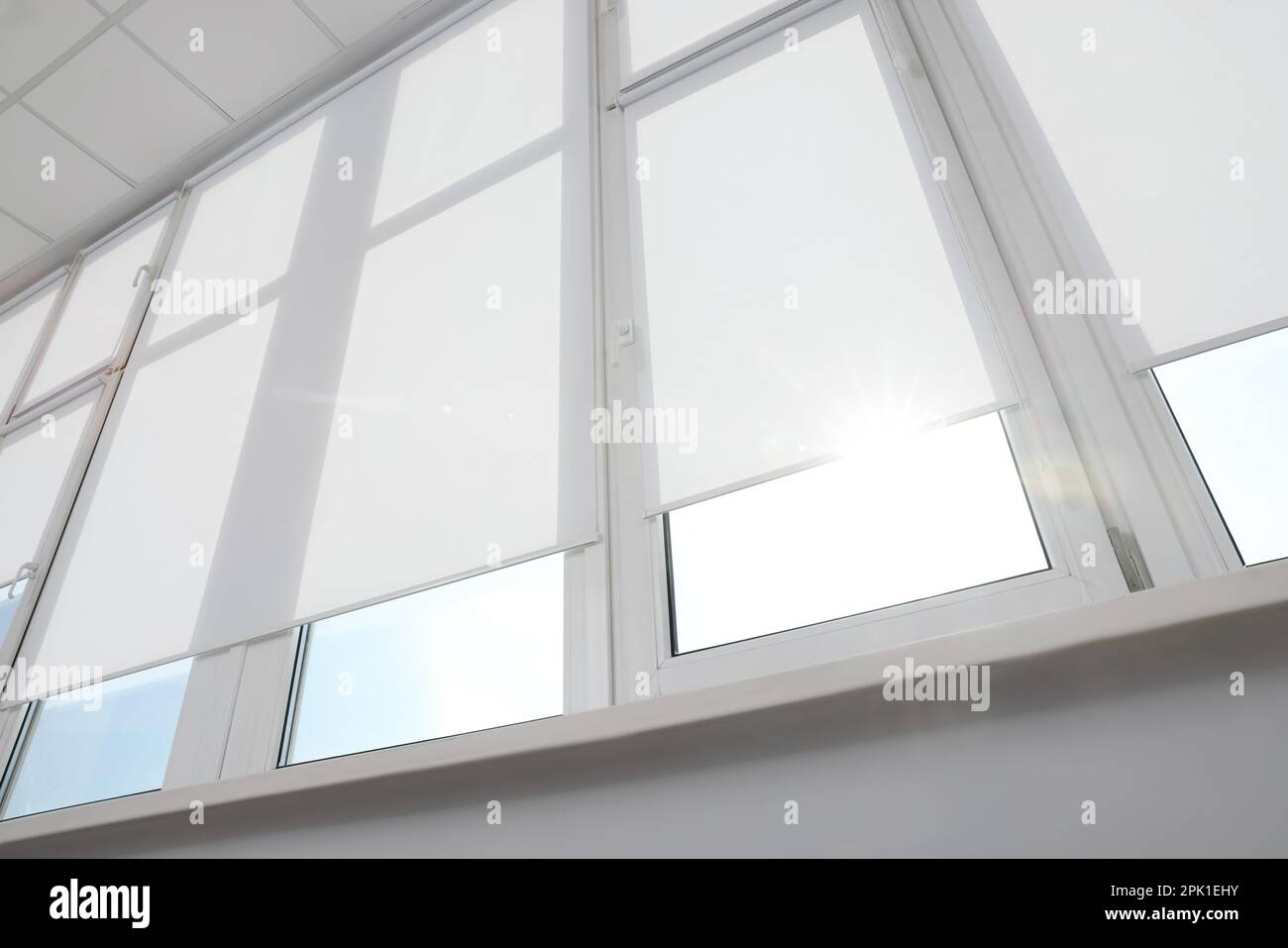 Gran ventana con persianas enrollables blancas en el interior