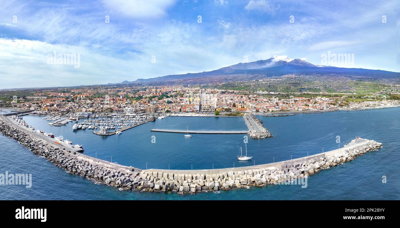 Destino de verano Riposto - vista aérea desde arriba en el puerto marítimo con barcos durante el día soleado con volcán Etna en el fondo con el mar Foto de stock
