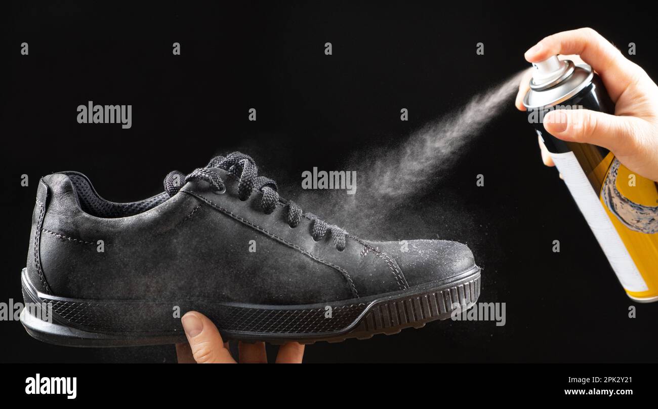 El proceso de aplicar un spray repelente al agua en los zapatos de  demi-temporada de nobuck de los hombres negros Fotografía de stock - Alamy