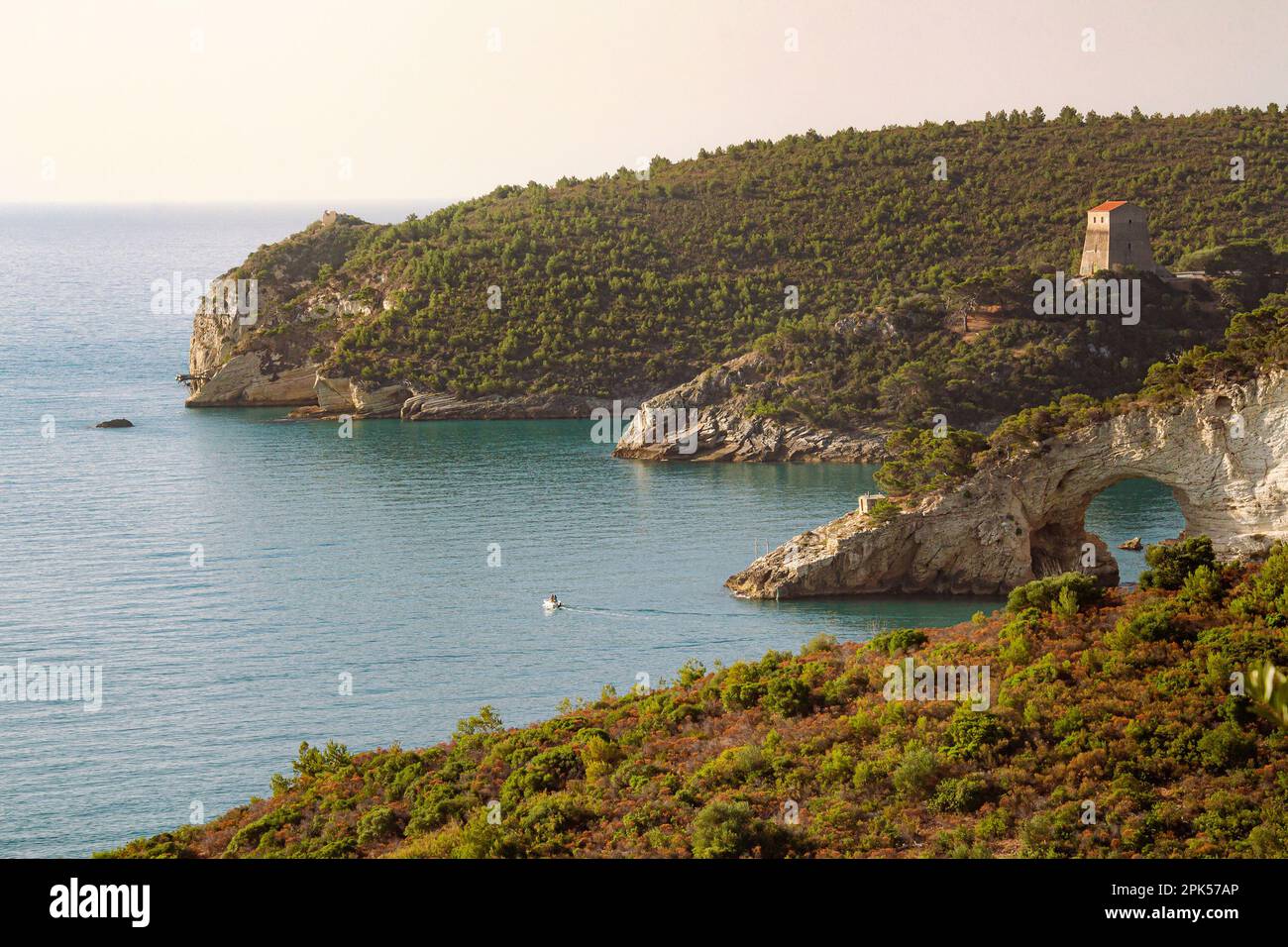 Vista del amanecer al arco de San Felice - Un arco de piedra caliza formado naturalmente Arco e Torre di San Felice cerca de la ciudad de Vieste, Foggia, Italia Foto de stock