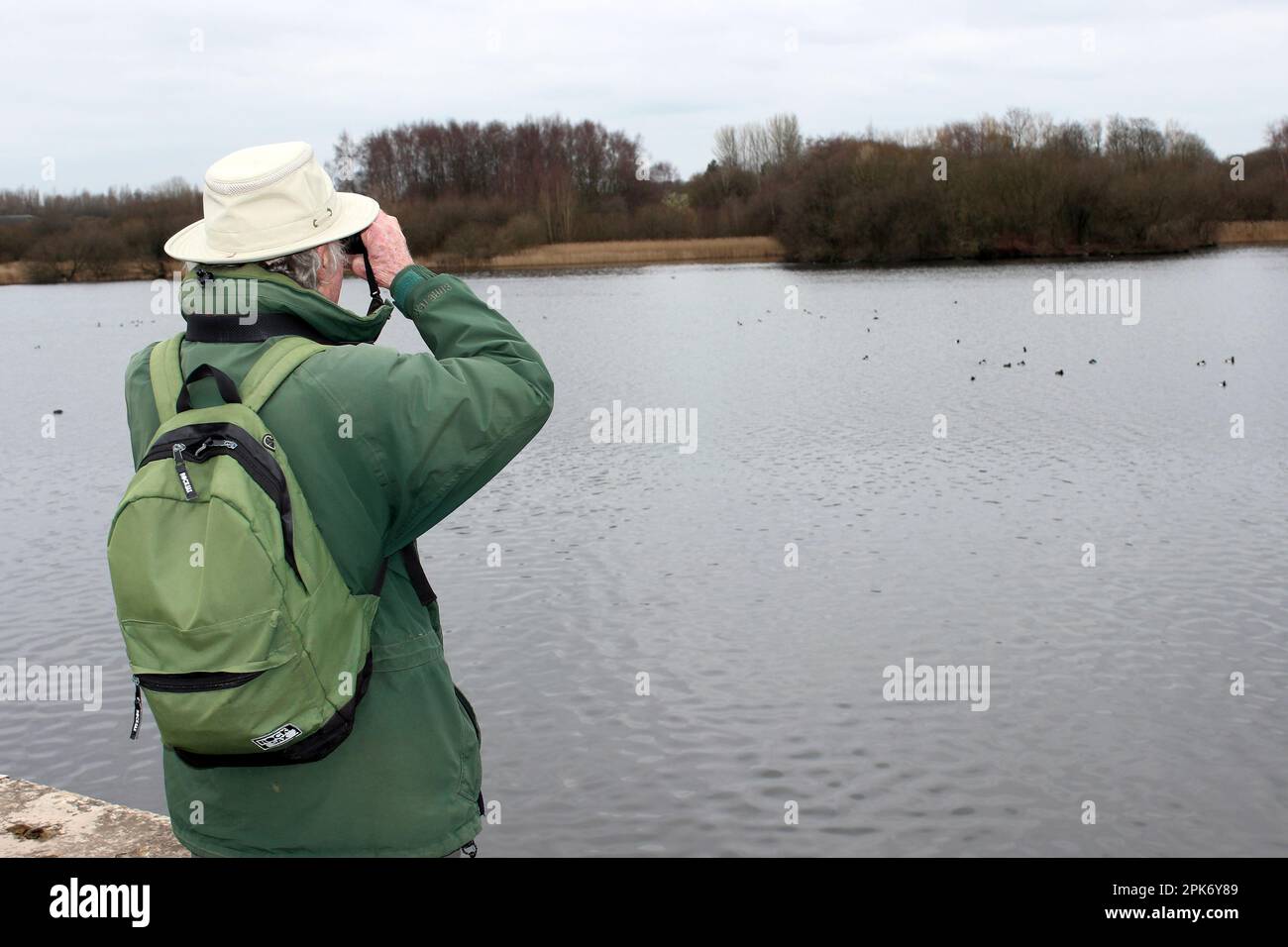 Observador de aves masculino mayor en la reserva natural de Wigan Flashes Foto de stock