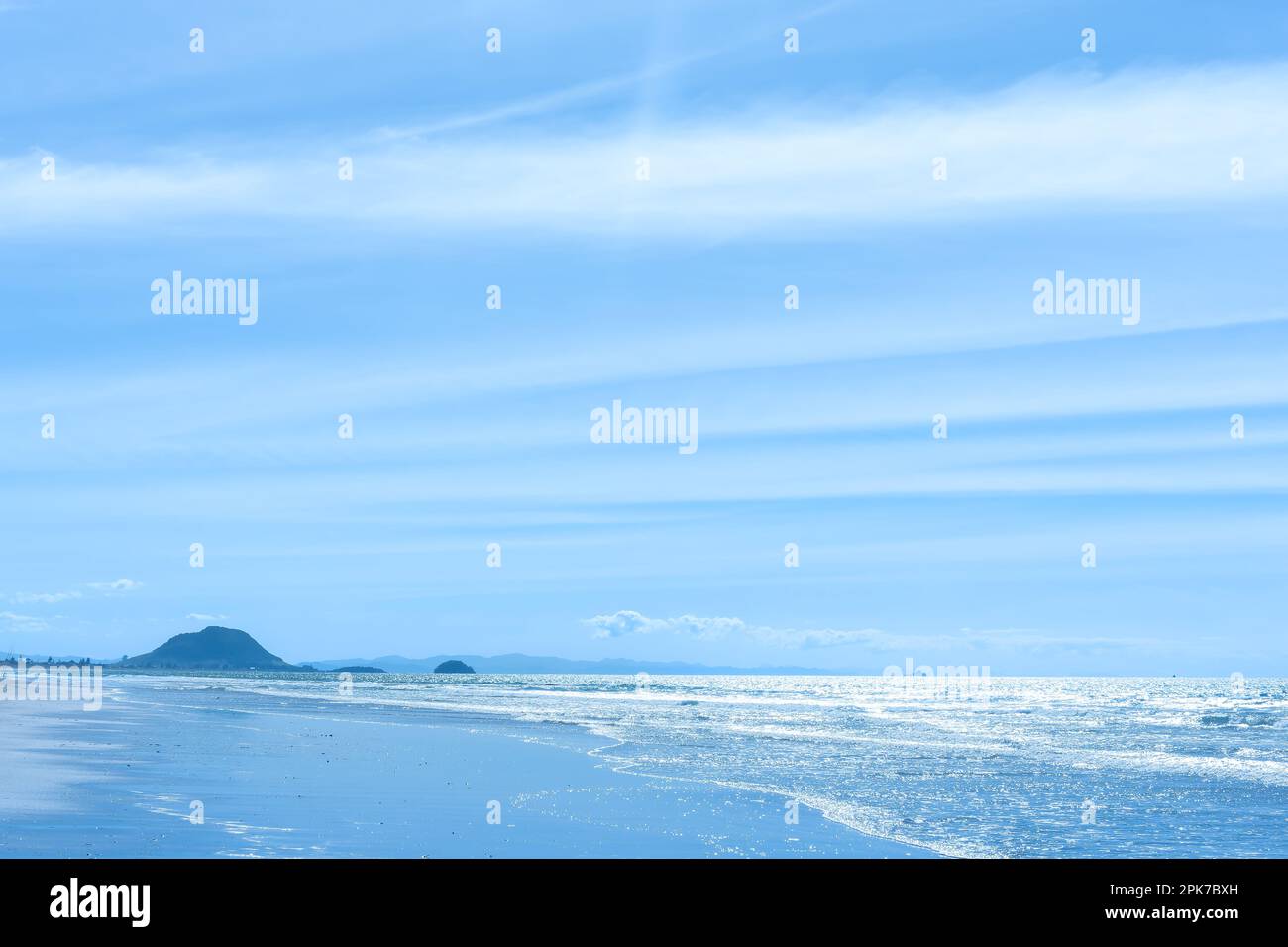 Fondo de tonos azules imagen costera a lo largo de la playa de Papamoa hasta el monte Maunganui. Foto de stock