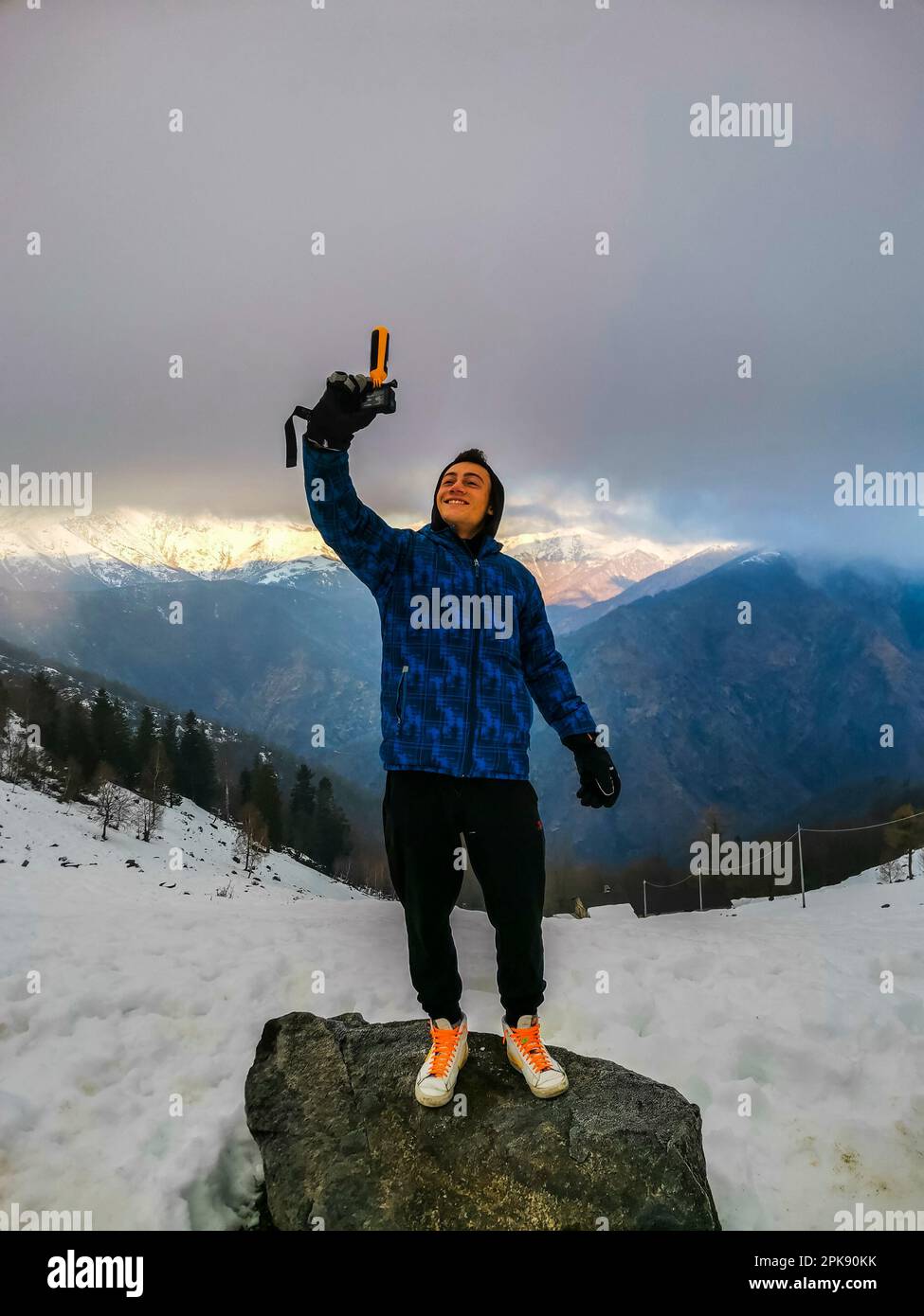 Un chico, selfie shot, cámara de acción, piedra, de pie, paisaje de montaña, invierno, Foto de stock