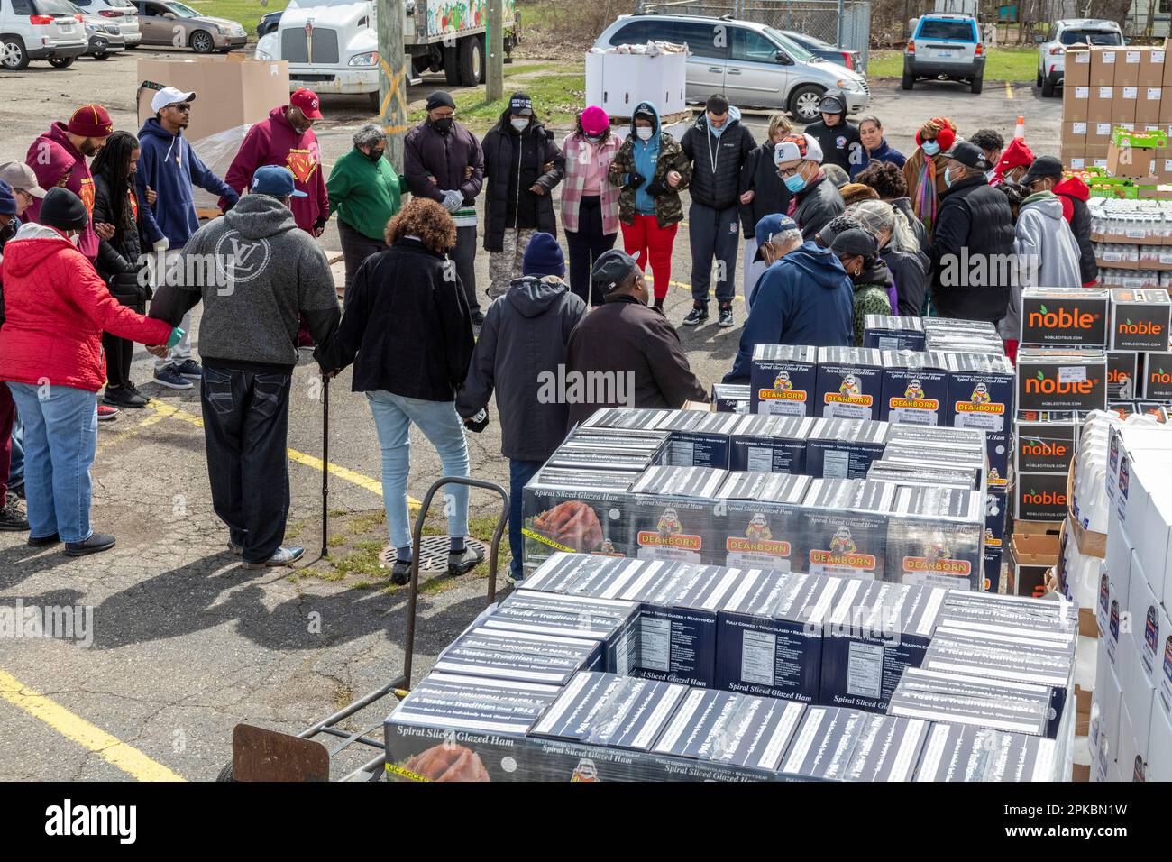 Inkster, Michigan, EE.UU. 6th de abril de 2023. Los voluntarios oran fuera de la Iglesia Womack Temple antes de distribuir 500 jamones para Pascua y otros comestibles a los necesitados, algunos de los cuales esperaron en fila seis horas. La iglesia opera una despensa de alimentos y distribuye comestibles a cientos de personas semanalmente. Más de un tercio de los residentes de Inkster viven por debajo de la línea de pobreza. Crédito: Jim West/Alamy Live News Foto de stock