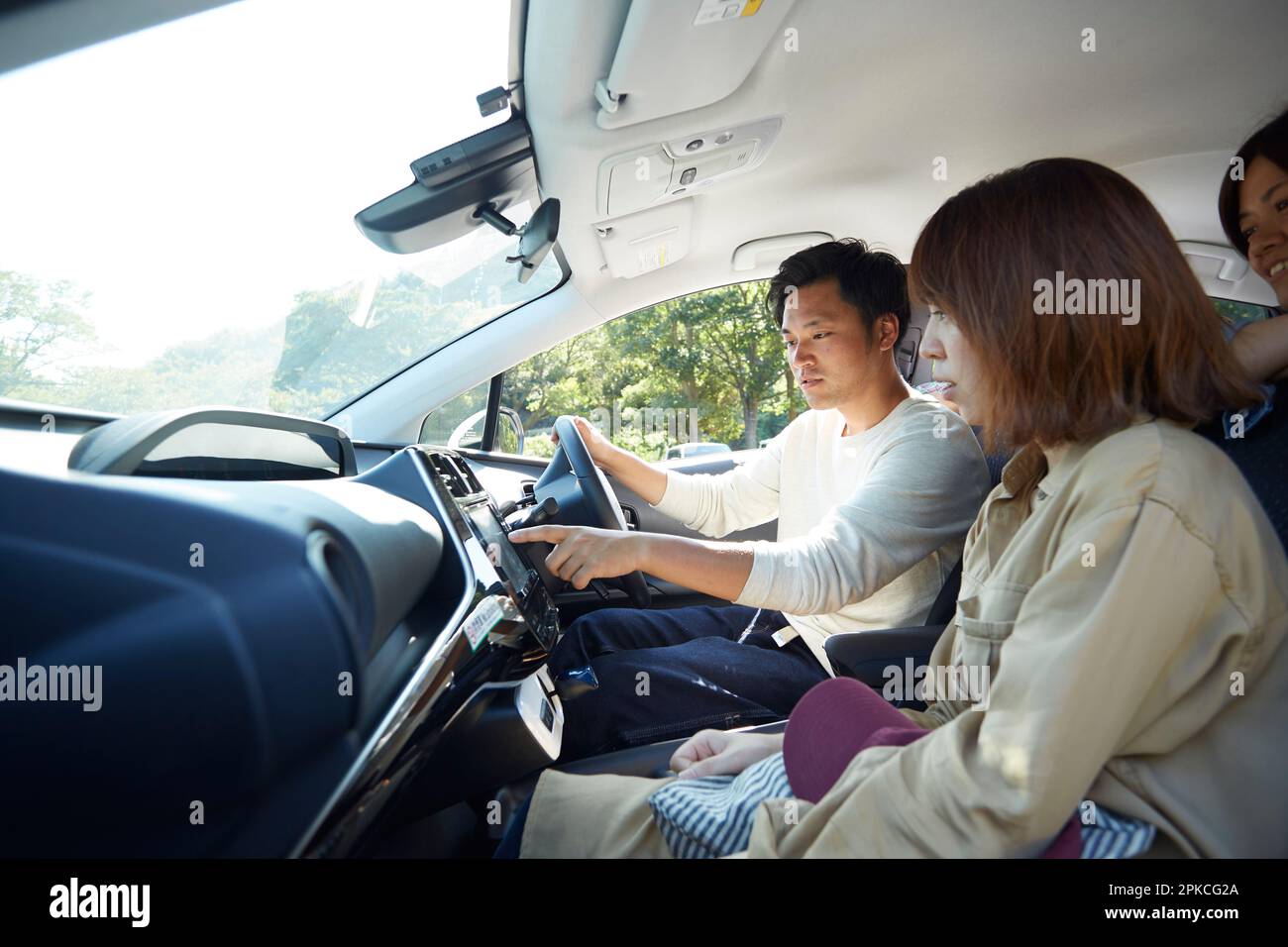 Dentro de un coche donde un hombre y una mujer están hablando y señalando el sistema de navegación del coche Foto de stock