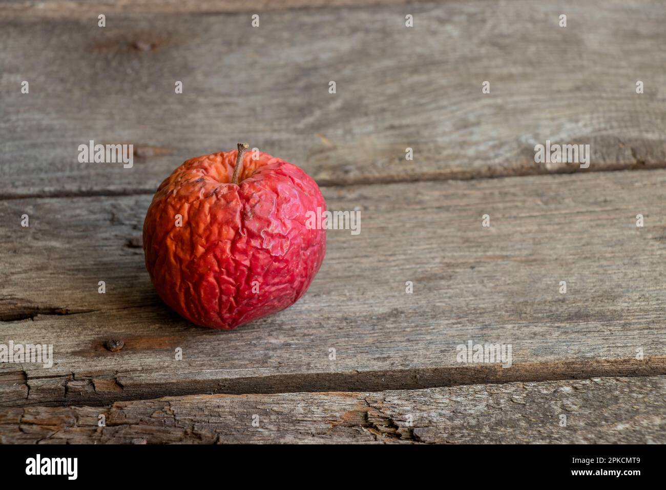 manzana podrida en una mesa de madera primer plano Foto de stock