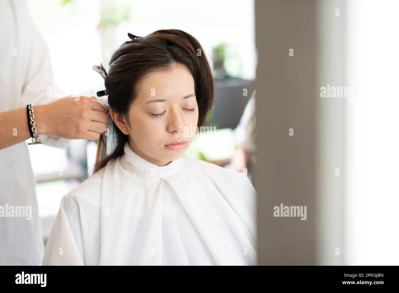Mujer que tiene su pelo fijado por un esteticista Foto de stock