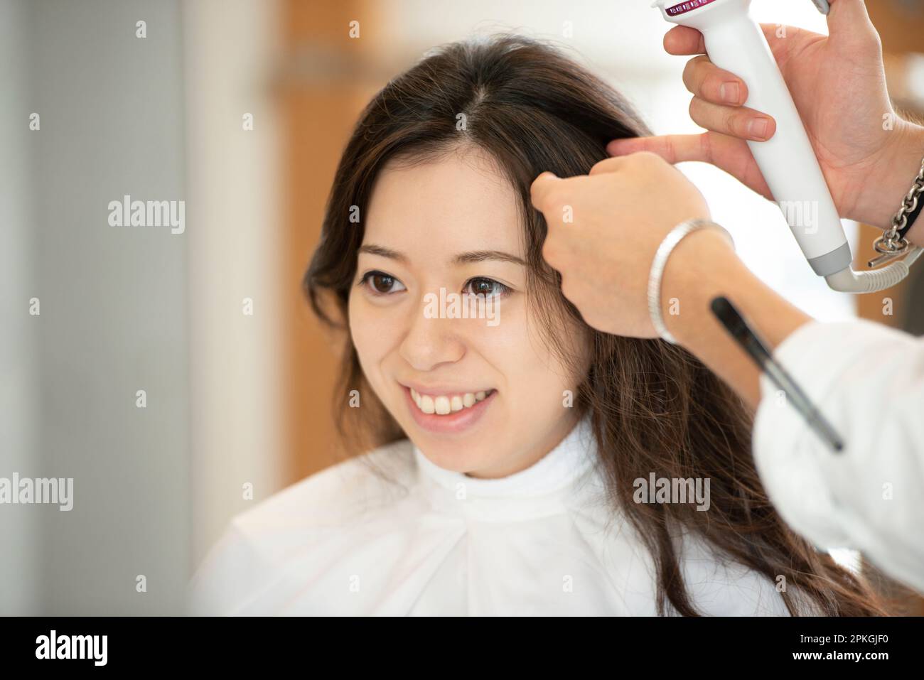 Mujer que tiene su pelo fijado por un peluquero Foto de stock