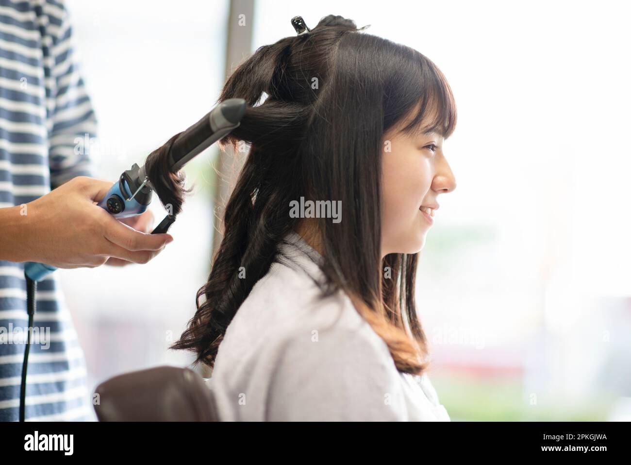 Mujer que tiene su pelo fijado por un esteticista Foto de stock