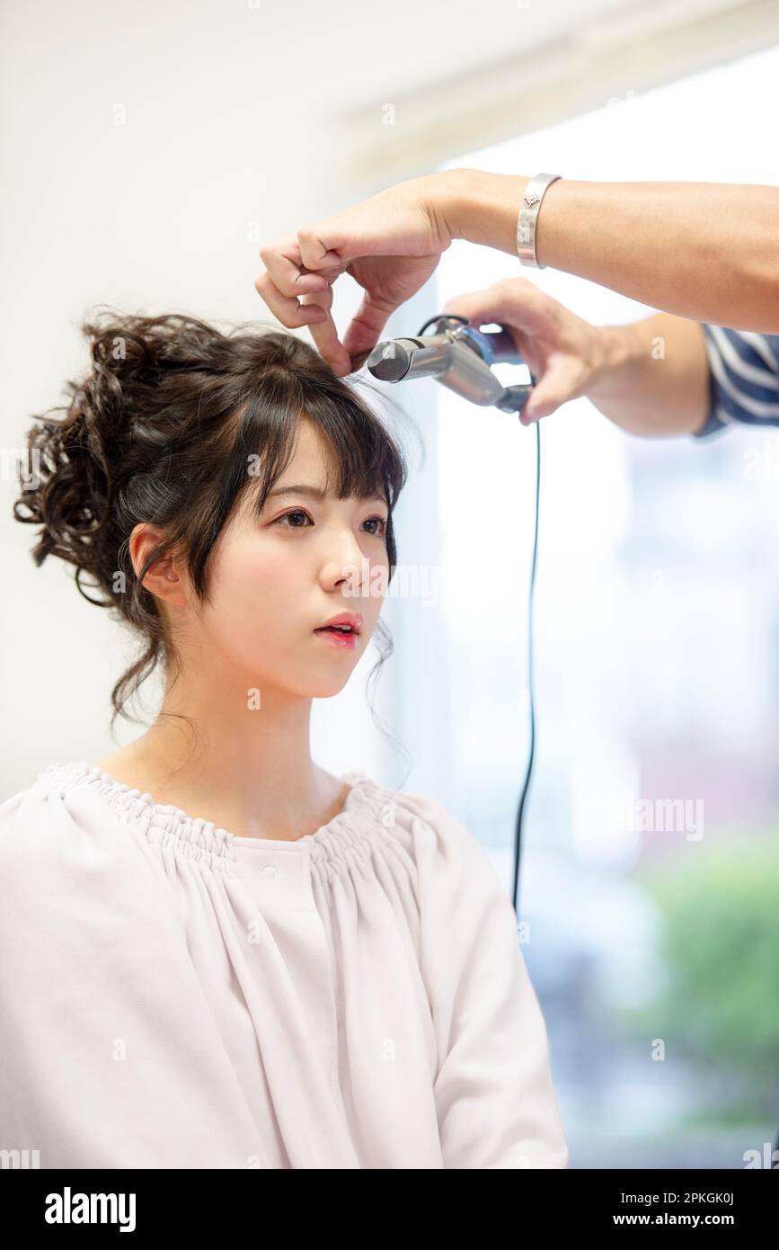 Mujer consiguiendo su pelo hecho por un peluquero Foto de stock