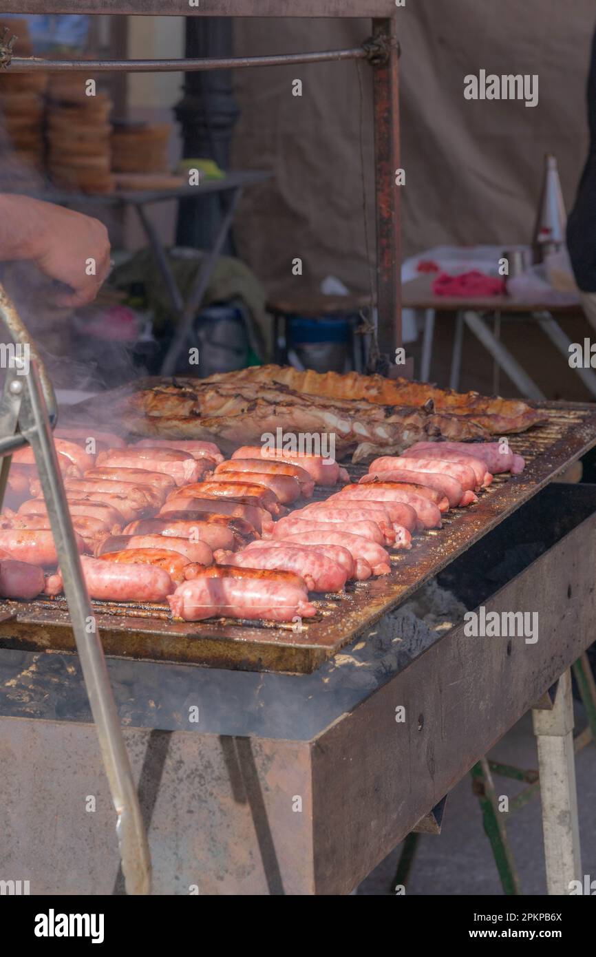 comida callejera, carne sabrosas salchichas a la parrilla, cocinar en carbón al aire libre Foto de stock