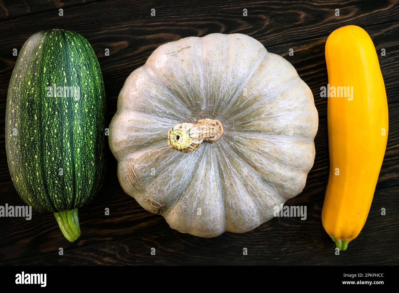 Calabaza y médula vegetal en la mesa de madera oscura, plana. Vista superior de calabacín fresco en tablones vintage, conjunto de alimentos orgánicos. Concepto de squash, coo Foto de stock