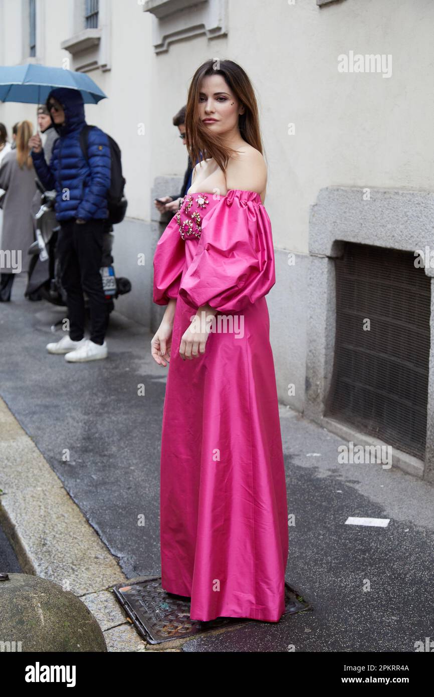 MILÁN, ITALIA - 26 DE FEBRERO de 2023: Mujer con vestido rosa con bordado de pedrería antes del desfile de Luisa Spagnoli, estilo callejero de la Semana de la Moda de Milán Foto de stock