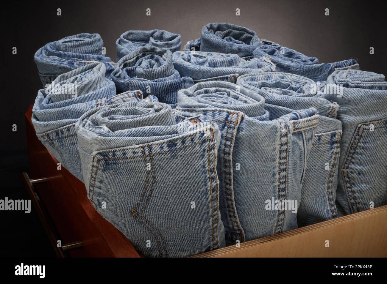 Jeans azules desteñidos, enrollados y organizados Foto de stock