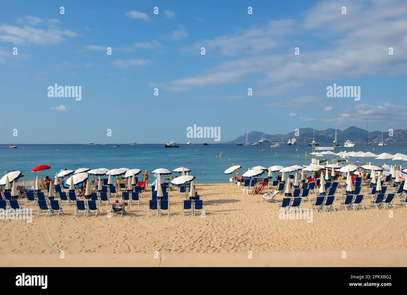La playa privada del Hotel Martinez en La Croisette en Cannes, en el sur de Francia, con tumbonas, sombrillas y embarcadero. Foto de stock