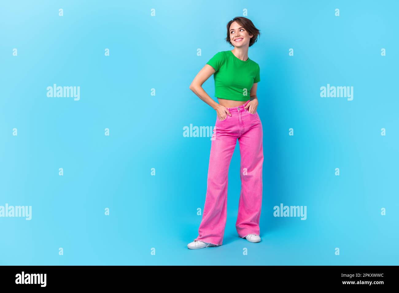 Foto de cuerpo completo de mujer soñadora que usa camiseta verde pantalones  rosas manos bolsillos espacio vacío anuncio de ropa barata aislado en fondo  de color aguamarina Fotografía de stock - Alamy