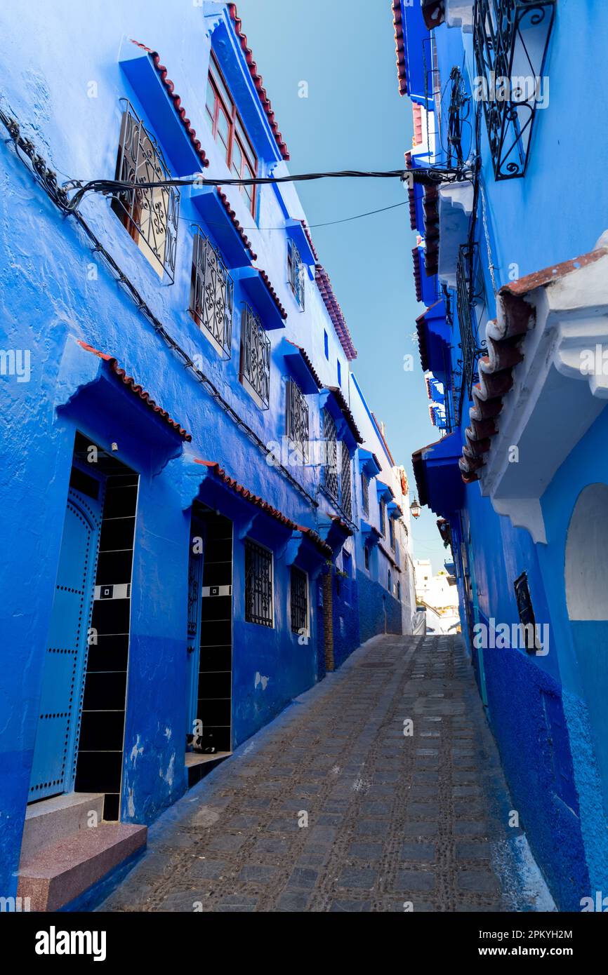 Las calles típicamente estrechas con las casas pintadas de azul en la ciudad azul de Chefchauen en Marruecos Foto de stock