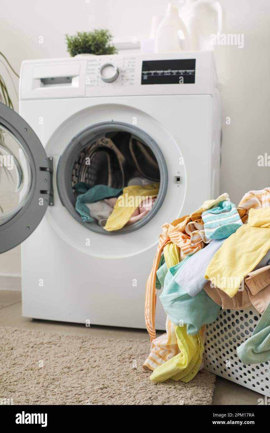 Cesta con ropa sucia y lavadora en lavadero Fotografía de stock - Alamy