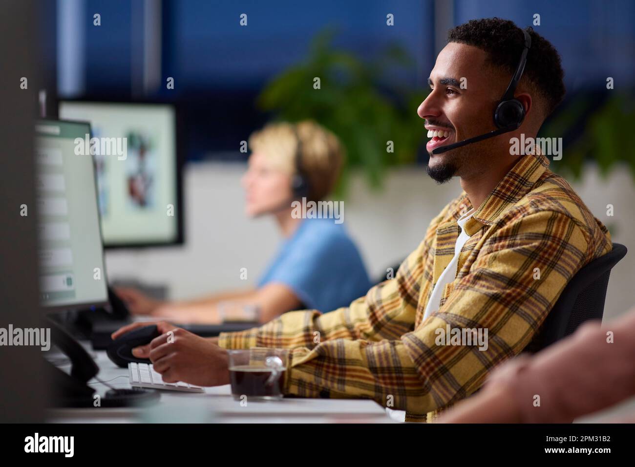 El equipo empresarial lleva auriculares trabajando hasta tarde en el centro de atención al cliente Foto de stock