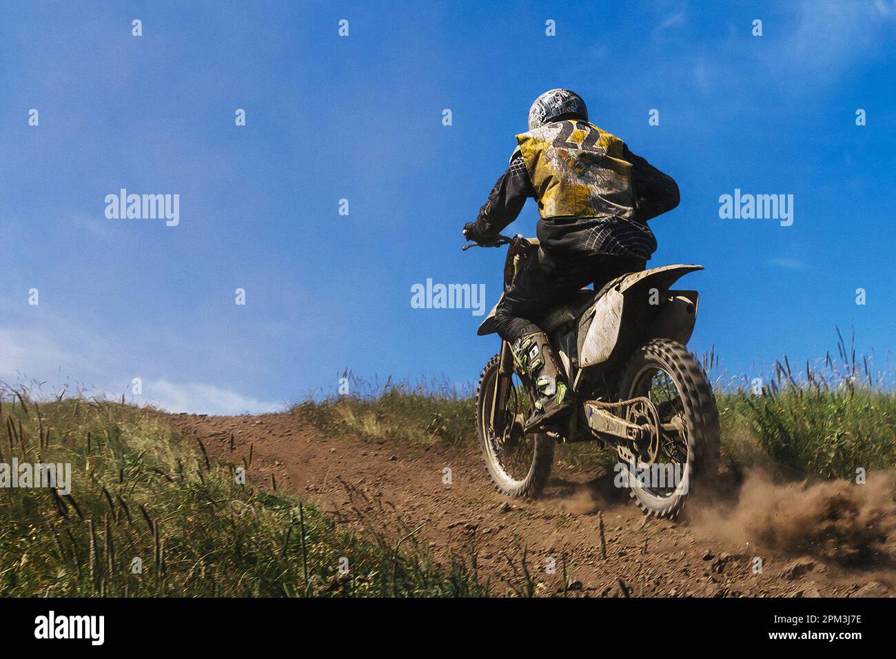 motocross jinete que conduce fuera de carretera pista de carreras de motocicletas, tierra y polvo de debajo de la rueda trasera Foto de stock