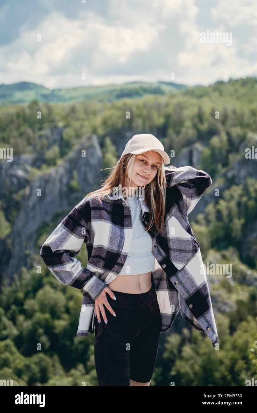 chica en un gorro una camisa a cuadros en un paisaje de monta a