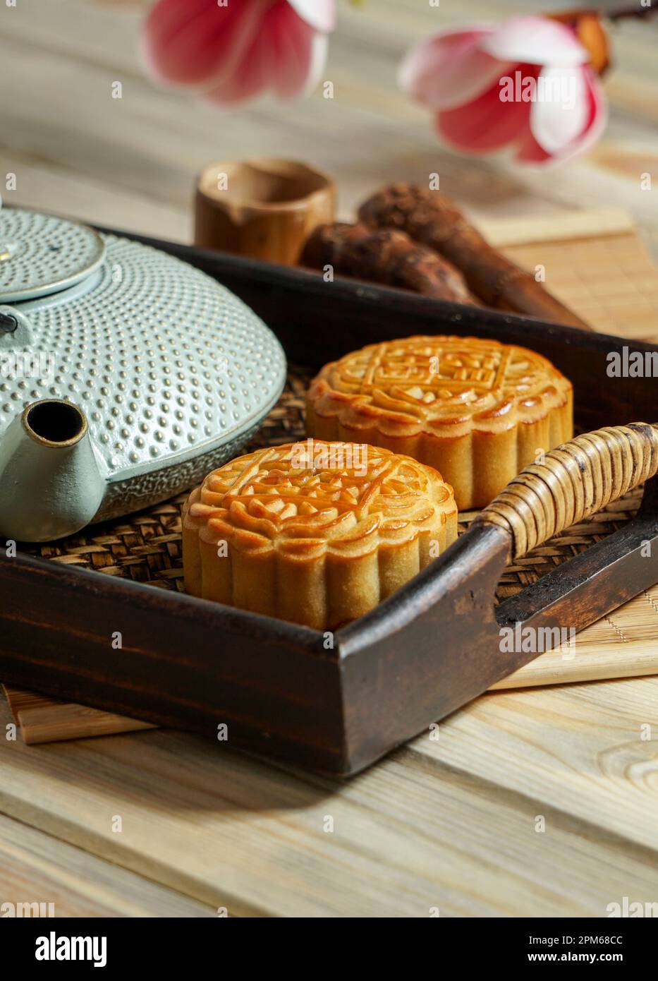 Mooncake para el Festival de mediados de otoño, concepto de comida china festiva tradicional en una bandeja de madera asiática con tetera Foto de stock