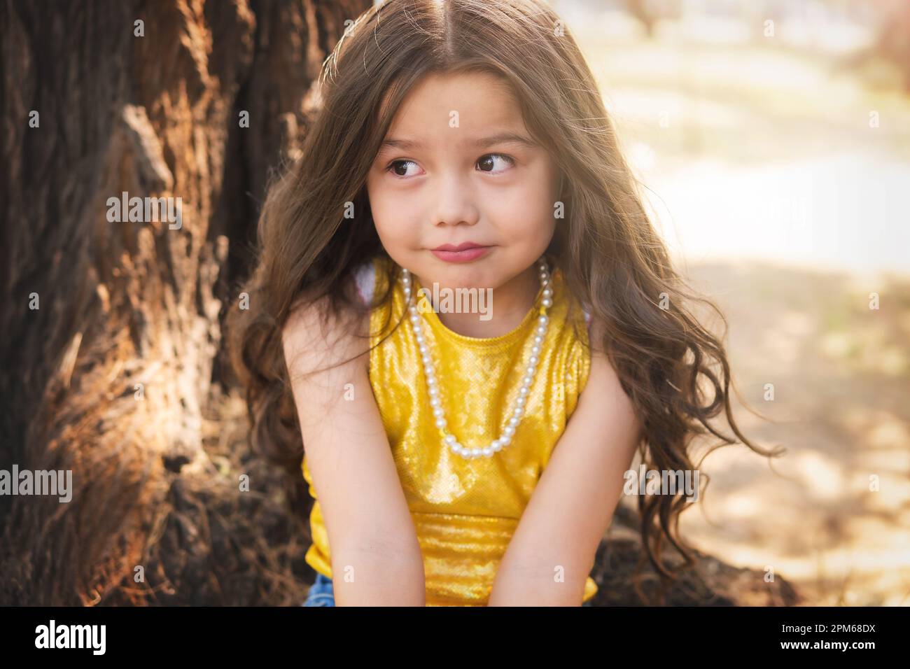 Expresión dudosa de una niña, hermosa chica rubia, tema del día de los niños. Foto de stock