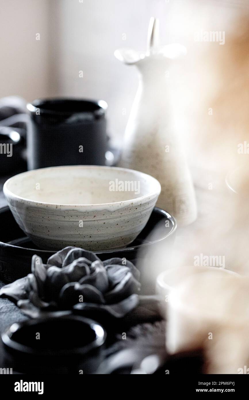 Mesa rústica con vajilla de cerámica artesanal vacía, cuencos ásperos  blancos y negros, tazas, jarra y jarrón sobre mantel de lino. Flor de caña  seca Fotografía de stock - Alamy