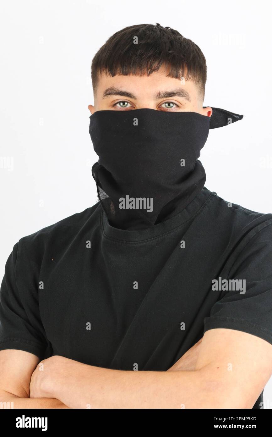 Adolescente que lleva una máscara negra contra un fondo blanco Foto de stock