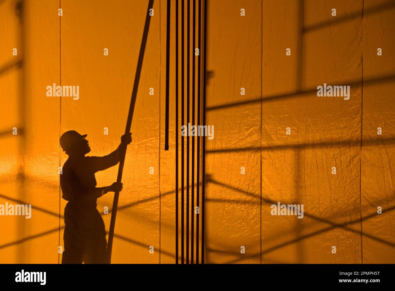 Silueta de un trabajador de la construcción sosteniendo un poste; Estados Unidos de América Foto de stock