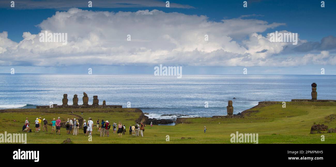 Los turistas se paran frente a Moai en Ahu Tahai, Isla de Pascua. Foto de stock