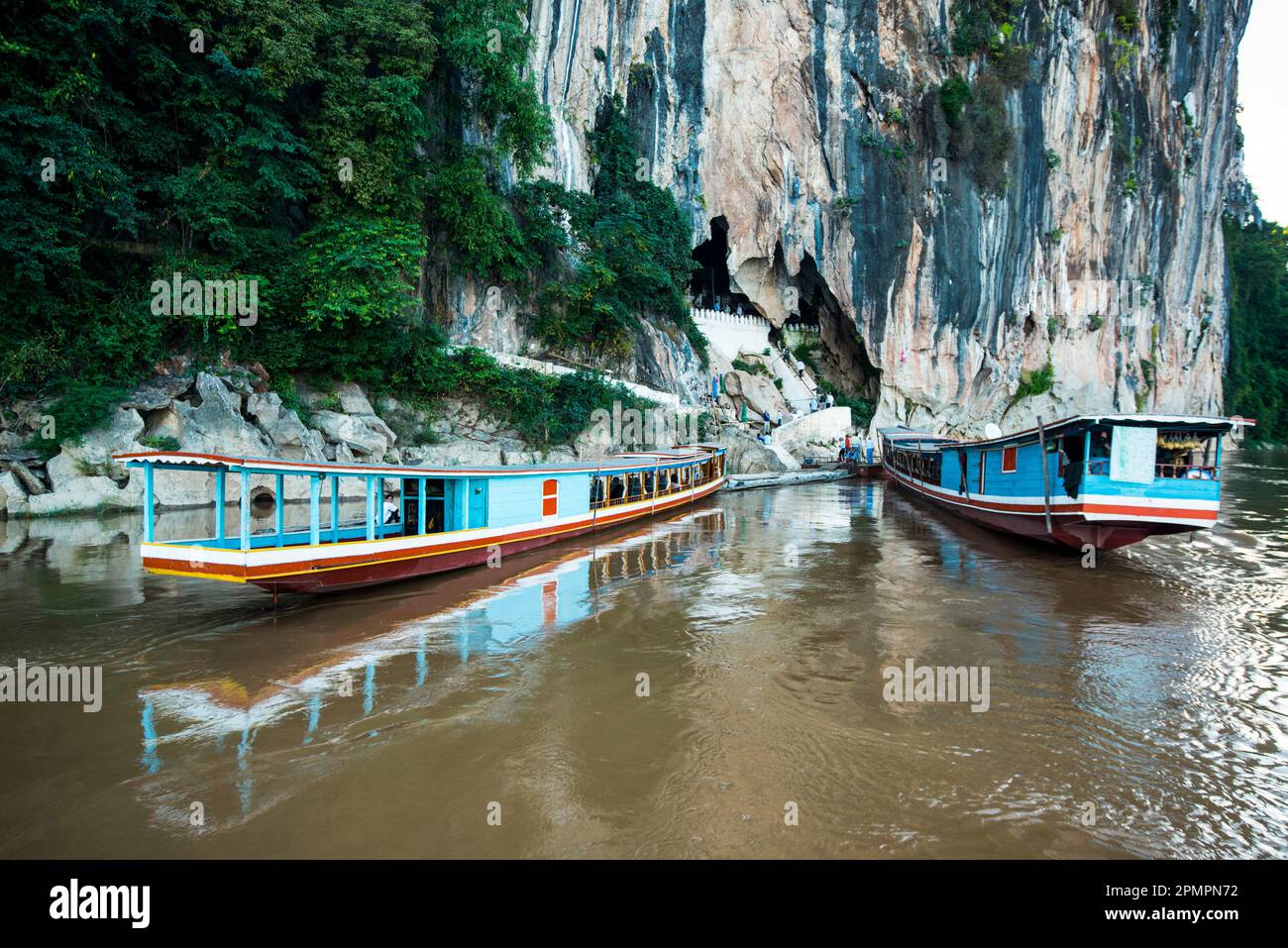 Dos cruceros atracaron en las cuevas Pak Ou, en el río Mekong. Foto de stock