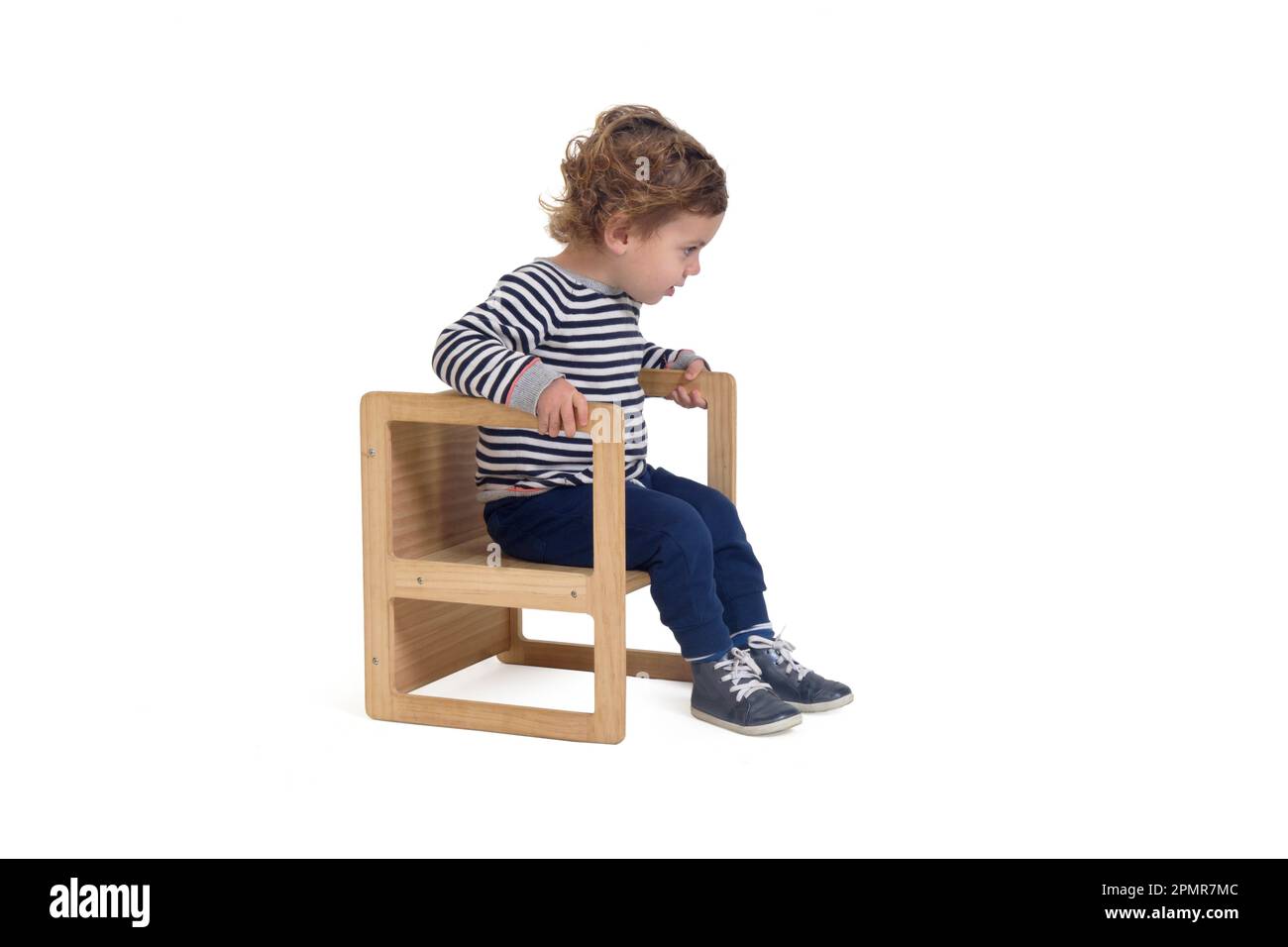 vista lateral de un niño sentado en silla y mirando hacia abajo sobre fondo  blanco Fotografía de stock - Alamy